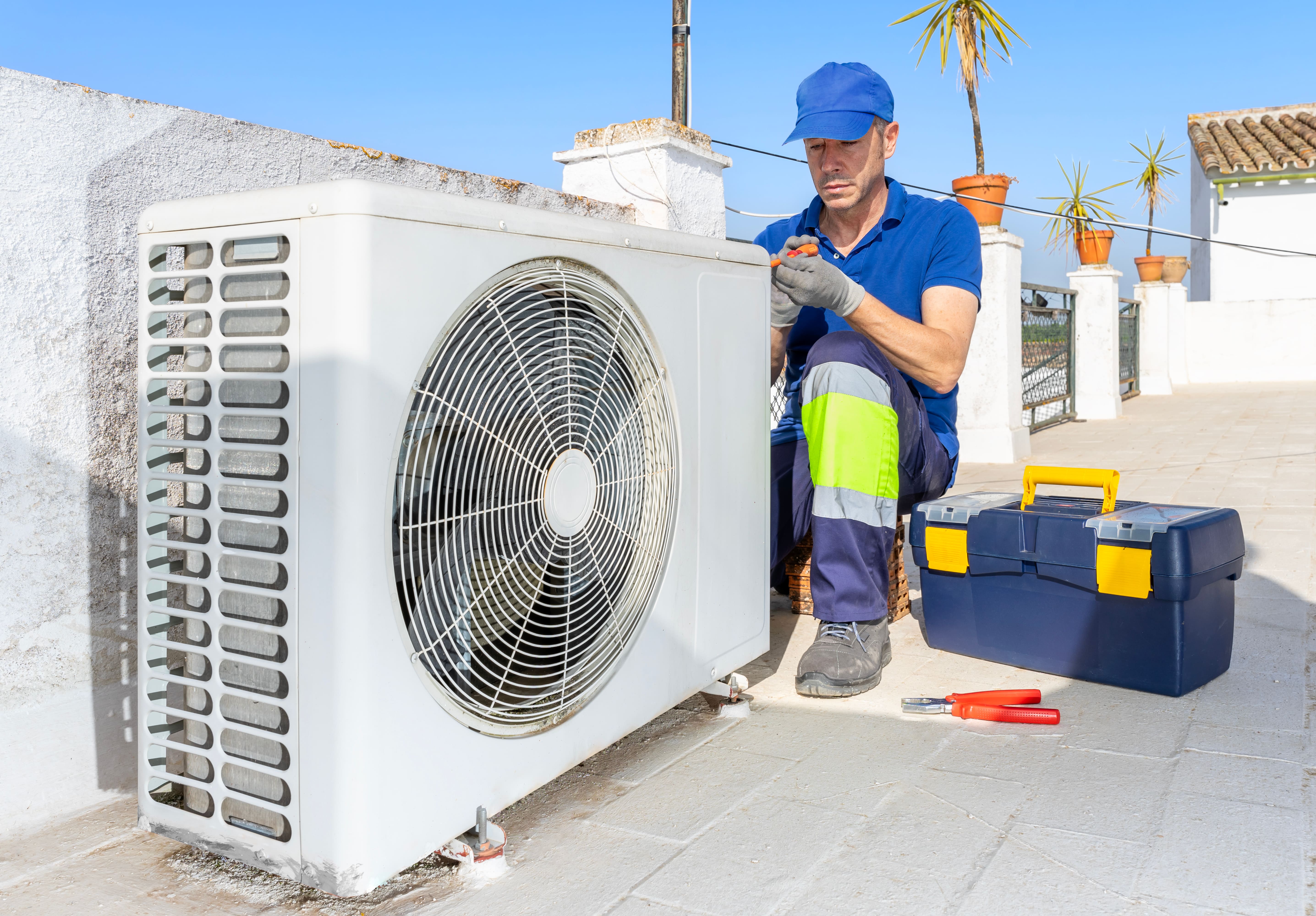 HVAC technician performing a professional furnace tune-up during the fall shoulder season.